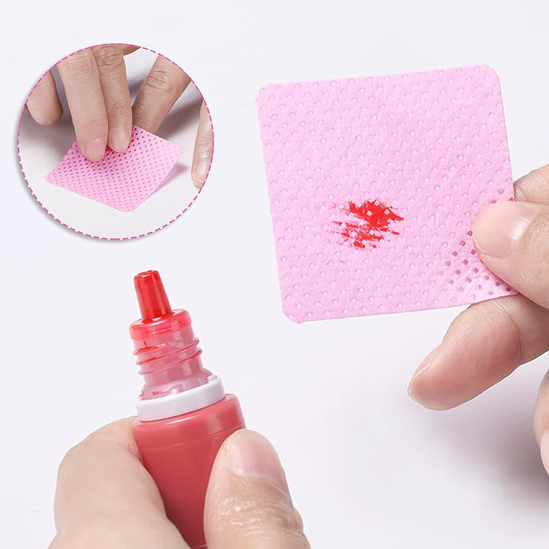 Demonstration of Ruby Beauty pink nail wipe absorbing red liquid, highlighting its strong absorption and no-shedding properties.