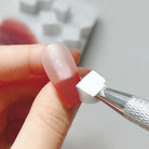 Sponge tool applying ombre design to a nail with red polish.